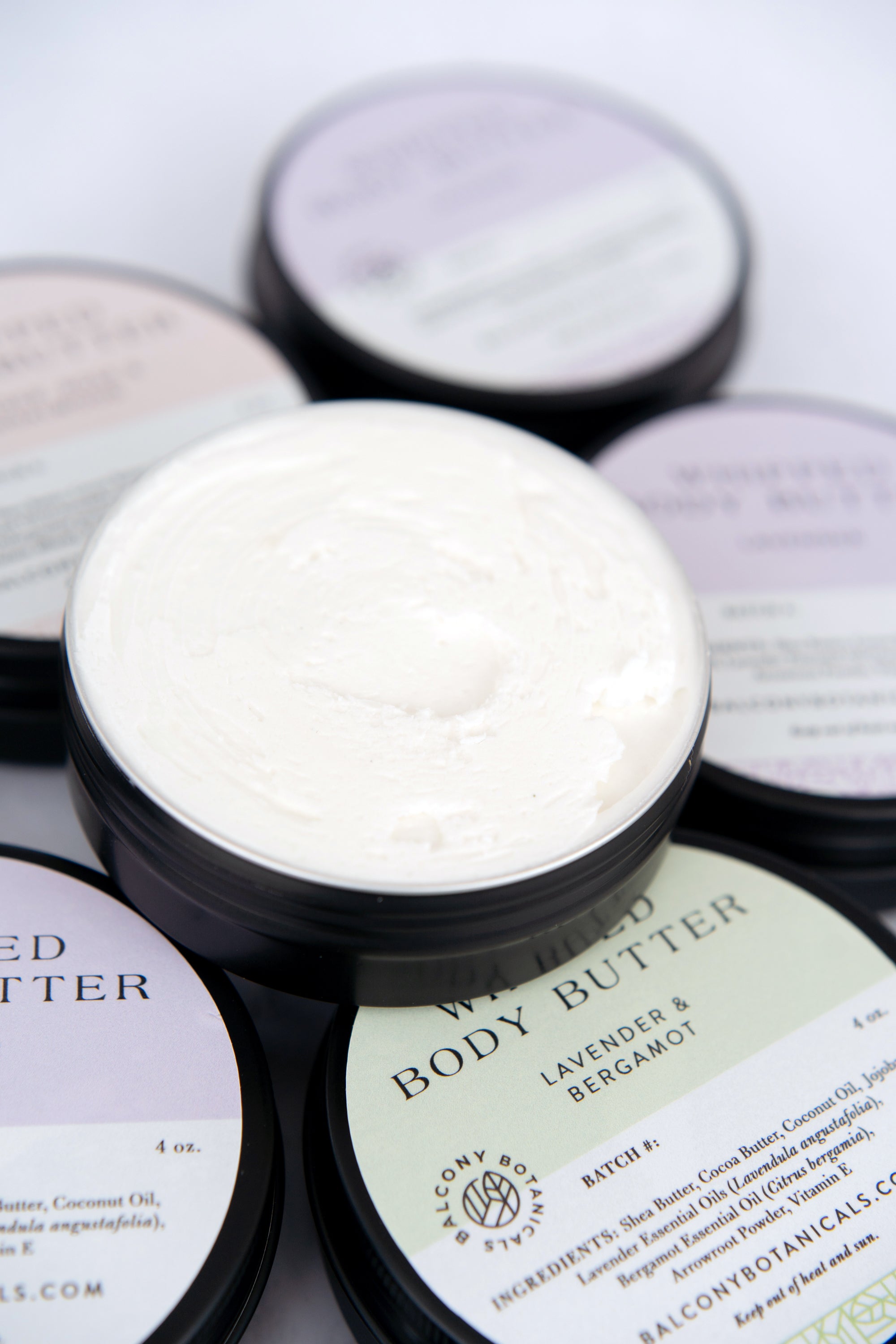 Tins of Whipped Body Butter all three scents with one tin open to see butter