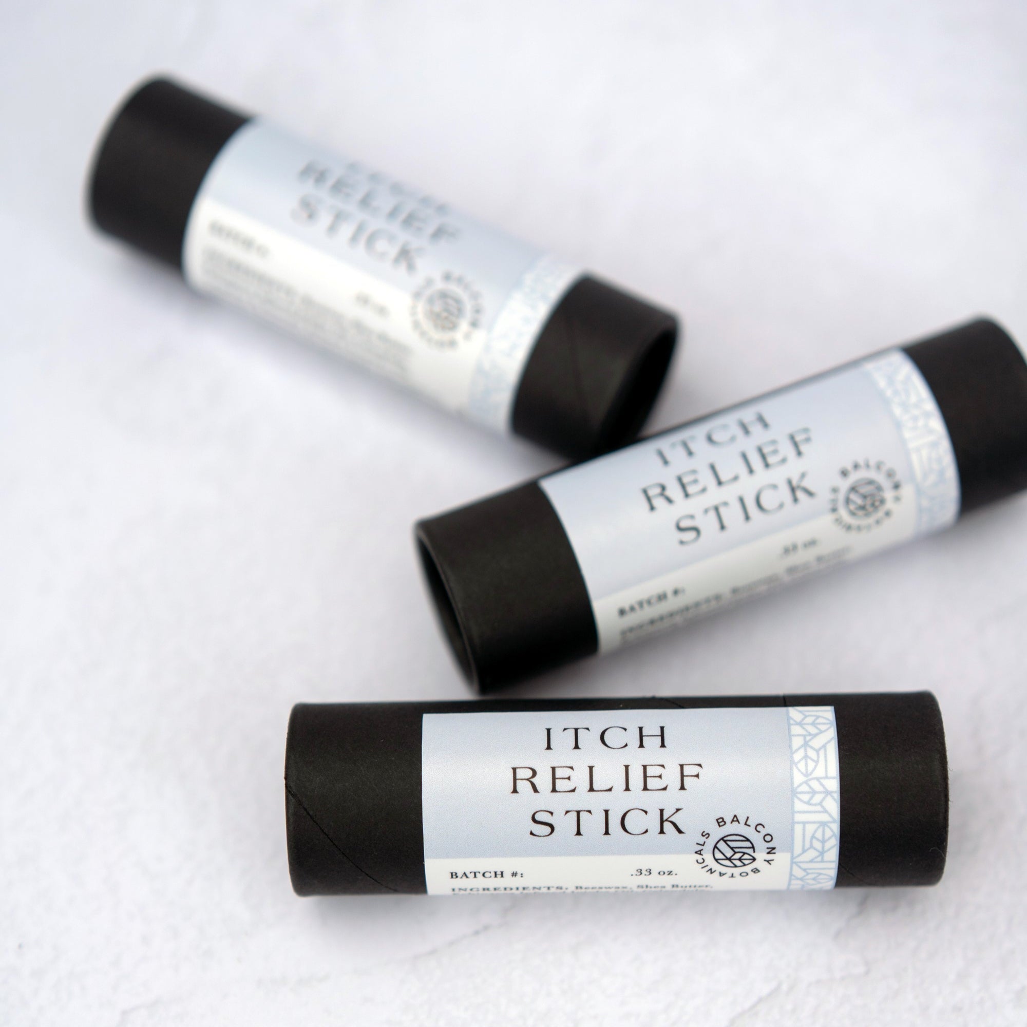 Three Itch Relief Sticks on a flat surface